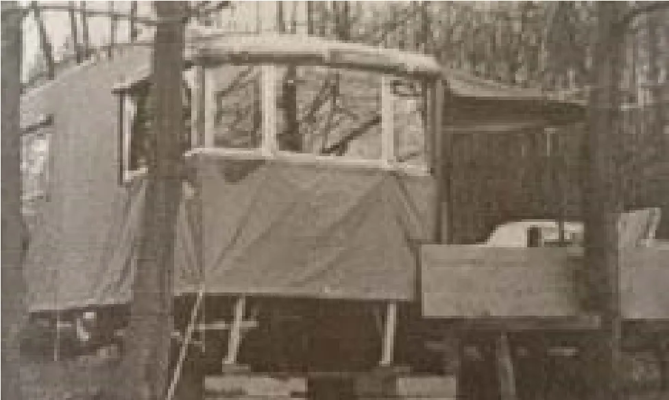 Frühes Clubgelände: ein selbstgebauter Wohnwagen mit Plane zwischen Bäumen.
